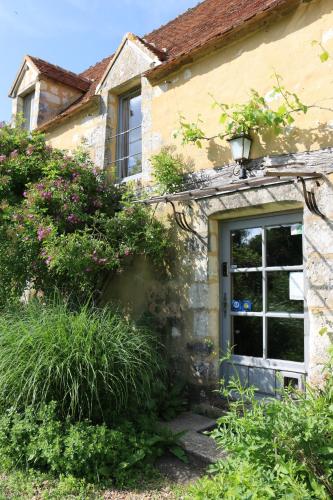 a stone house with a door and a window at Le bourgis in La Chapelle-Montligeon