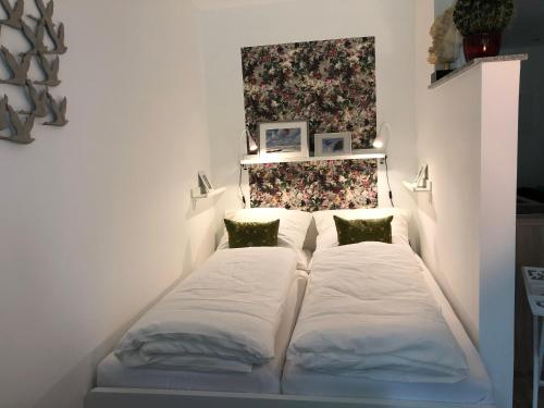 Bett in einem Zimmer mit zwei Kissen in der Unterkunft Hamptons No.2 in Scharbeutz