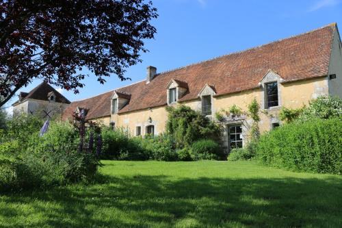an old house with a grass yard in front of it at Le bourgis in La Chapelle-Montligeon