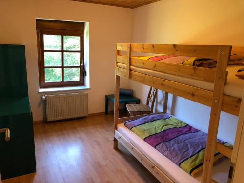 1 Schlafzimmer mit 2 Etagenbetten und einem Fenster in der Unterkunft Ferienhaus Werkhof in Schönau