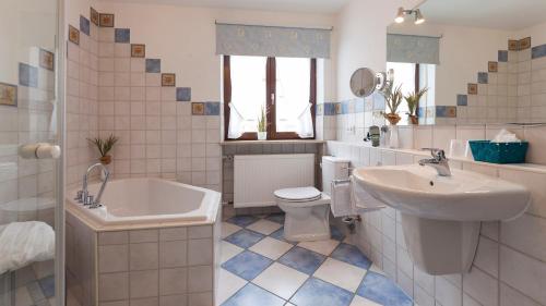a bathroom with a sink and a tub and a toilet at Hotel Restaurant Hansjakob in Hagnau