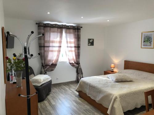 a bedroom with a bed and a window at Maison Tobias in Bussy-Saint-Georges