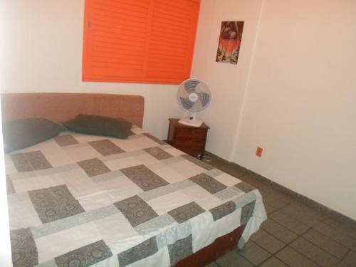 1 dormitorio con 1 cama y ventilador en Apartamento no Porto da Barra, en Salvador