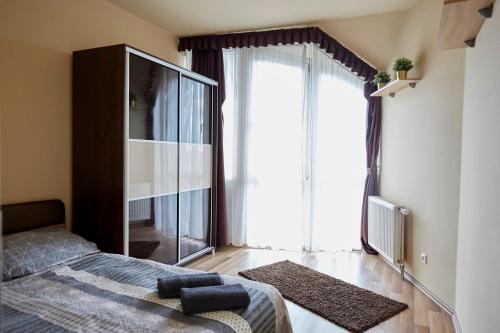 ein Schlafzimmer mit einem Bett und einem großen Fenster in der Unterkunft Prémium Home in Pécs