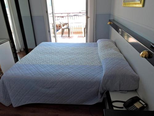 a bedroom with a bed and a window with a table at Hotel Capri in Lesa