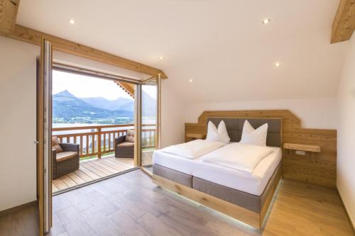 - une chambre avec un lit et un balcon dans l'établissement Altroiterhof, à Sankt Wolfgang im Salzkammergut