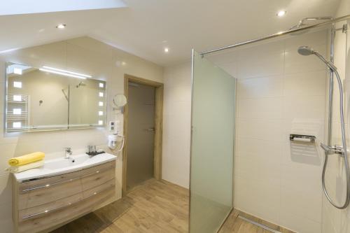 a bathroom with a sink and a glass shower at Altroiterhof in St. Wolfgang