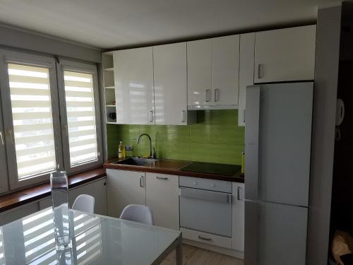 a kitchen with white cabinets and a refrigerator at APARTAMENT SŁONECZNY in Kołobrzeg