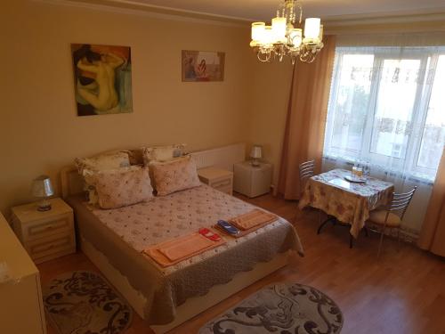 a small bedroom with a bed and a table at Navigator in Chernivtsi