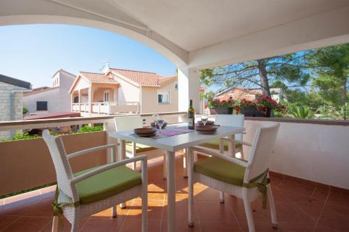 a white table and chairs on a balcony at Apartmani Luka in Vir