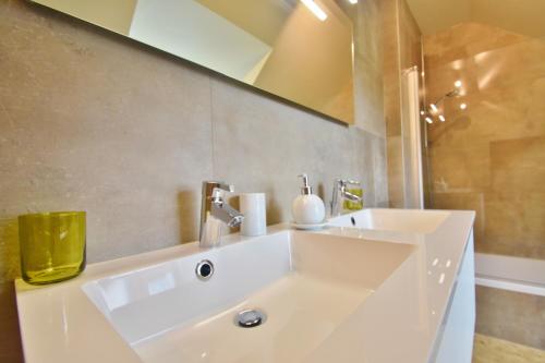 a bathroom with a white sink and a mirror at Enroute367 in Varsenare
