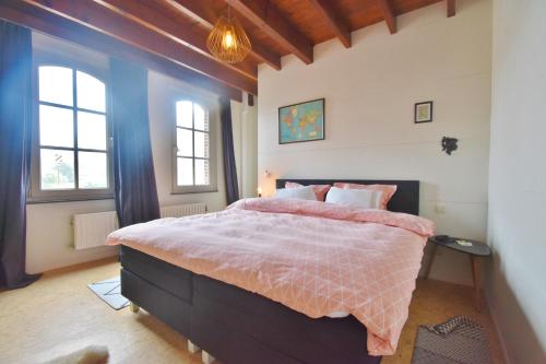 1 dormitorio con 1 cama y 2 ventanas en Enroute367, en Varsenare
