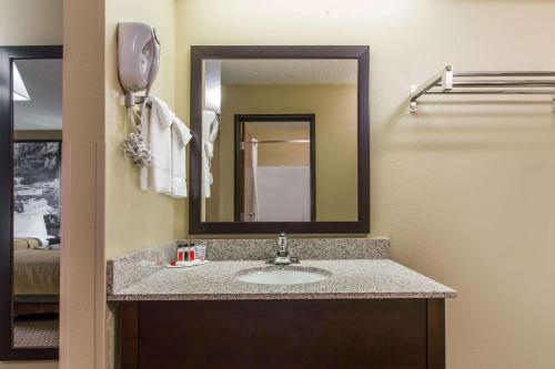 y baño con lavabo y espejo. en Super 8 by Wyndham Sun Prairie/Madison E, en Sun Prairie