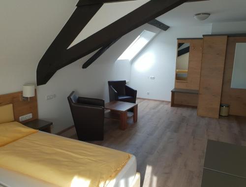 a bedroom with a bed and a table and chairs at ZUM ZIEL Hotel & Restaurant Grenzach-Wyhlen bei Basel in Grenzach-Wyhlen