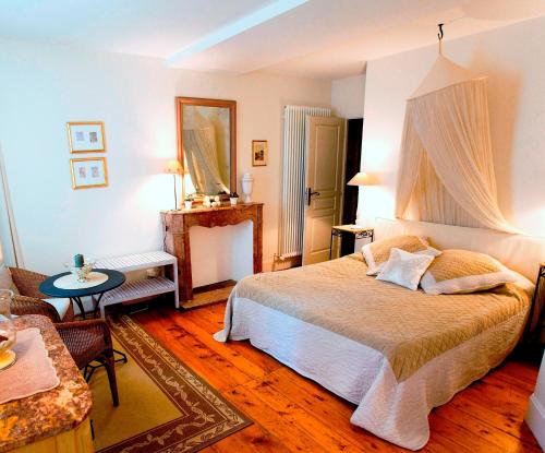 Saint-RomainにあるDomaine de la Corgetteのベッドルーム1室(ベッド1台、テーブル付)