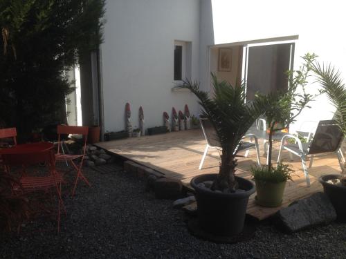 a patio with chairs and a palm plant in a pot at Gite des 3 cigognes in Colmar