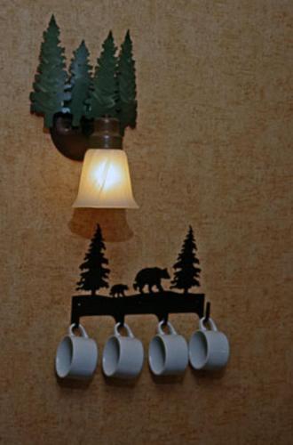 a light on a wall with a cup holder with bears and trees at Pepper Tree Inn Tahoe City in Tahoe City