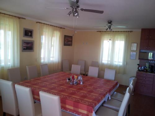 a dining room with a table and chairs and a table and chairsktop at Tó- Party Panoráma Panzió & Wellness in Kiszombor