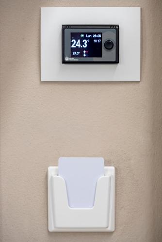 a digital clock on a wall with a white chair at Casa Ercoli B&B in Vinci