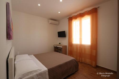 a small bedroom with a bed and a window at Villa Margherita in Marsala