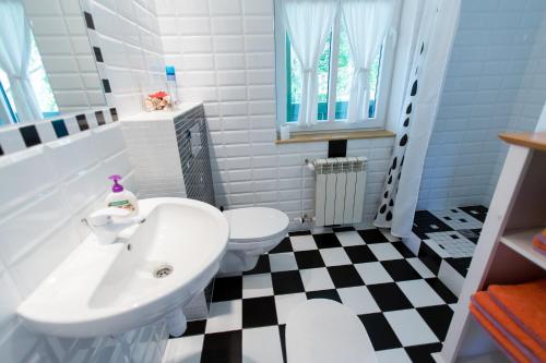 a bathroom with a black and white checkered floor at Dom pod Kogutem in Pasym