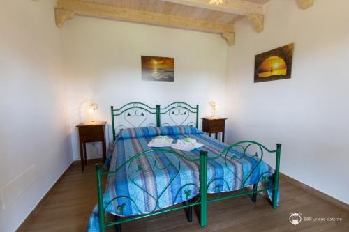 1 dormitorio con cama verde y edredón azul en B&B Le Due Cisterne, en Vernole