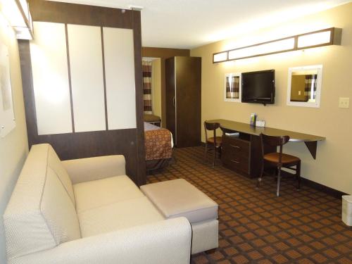 a hotel room with a couch and a table and a bed at Microtel Inn & Suites by Wyndham Harrisonburg in Harrisonburg