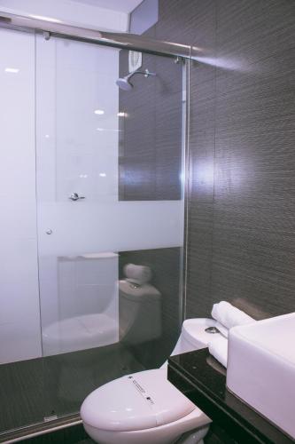a bathroom with a white toilet and a sink at Sunec Hotel in Chiclayo