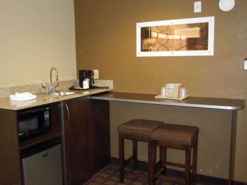 a kitchen with a counter and stools in a hotel room at Microtel Inn & Suites by Wyndham Harrisonburg in Harrisonburg