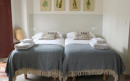 a bedroom with two beds with blankets and towels at Apartamentos Plaza Mayor in Gijón
