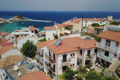 an aerial view of a town with houses and the ocean at Green Hill Studios & Apartments in Kokkari