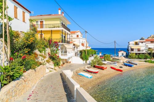 una playa con tumbonas junto al agua en Green Hill Studios & Apartments, en Kokkari