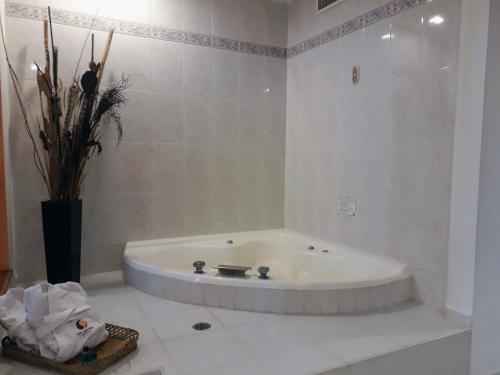 a white bathroom with a tub in a room at San Juan Park Hotel in San Juan del Río