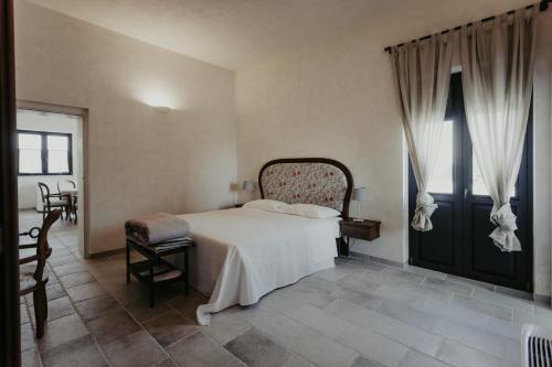 sypialnia z dużym łóżkiem i dużym oknem w obiekcie Masseria Sacramento w mieście Palagianello