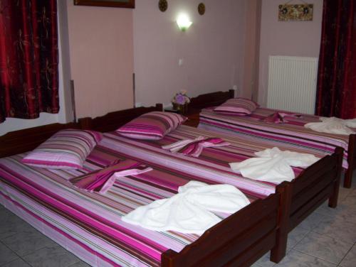 two beds with pink and white towels on them at Verginia Studios in Korinós