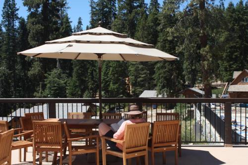 a person sitting at a picnic table under an umbrella at Montecito Sequoia Lodge in Sequoia