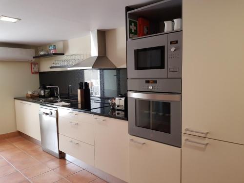 a kitchen with stainless steel appliances and white cabinets at OHH - Porto Boutique Guest House in Porto