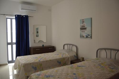 a bedroom with two beds and a dresser and a mirror at Mellieha Town Centre Bright & Spacious 3 Bedroom Apartment in Mellieħa