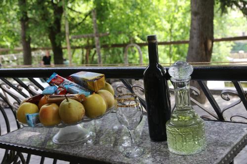 a table with a bowl of fruit and a bottle of wine at Hostel Saba in Kutaisi