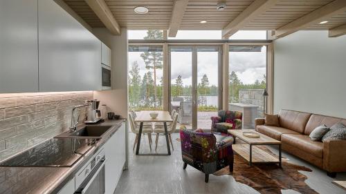 a kitchen and living room with a couch and a table at Naava Chalet First Floor in Ähtäri