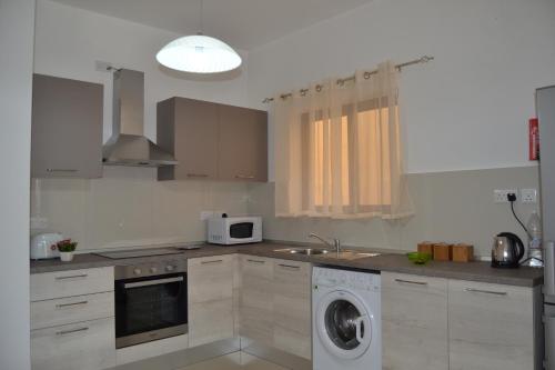 a kitchen with a washing machine and a sink at Mellieha Town Centre Bright & Spacious 3 Bedroom Apartment in Mellieħa