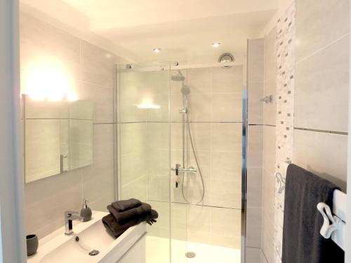 une salle de bain blanche avec une douche et un lavabo dans l'établissement L'Erdream, à Nantes