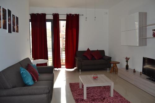 a living room with two couches and a table at Mellieha Town Centre Bright & Spacious 3 Bedroom Apartment in Mellieħa