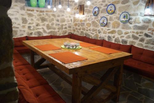 una mesa de madera en un restaurante con cabinas rojas en Vila Trebicka, en Korçë