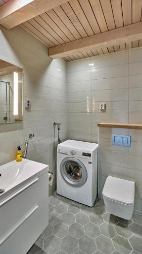 a bathroom with a washing machine and a sink at Naava Chalet First Floor in Ähtäri