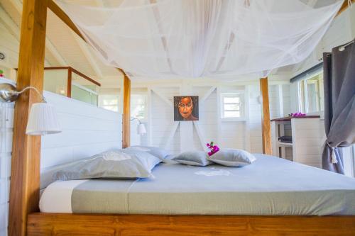 a large bed with a white canopy in a bedroom at Carre Royal in Deshaies