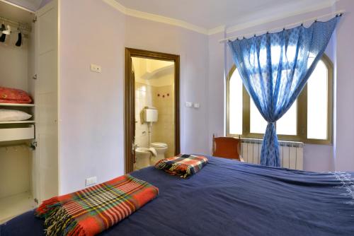 a bedroom with a blue bed with a window at il ricamo in Badalucco