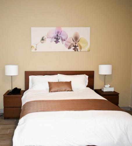 a bedroom with a large bed with two lamps at California Comfort & Suites in Los Algodones