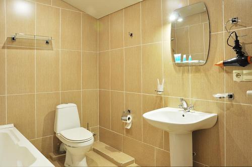 a bathroom with a toilet and a sink and a mirror at Hotel Corner in Tbilisi City