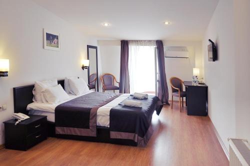 Habitación de hotel con cama, mesa y sillas en Hotel Corner en Tiflis